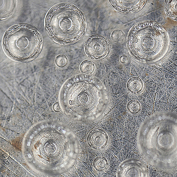 Пузыри воздуха в воде на фоне металла