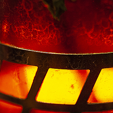 Просвечивающий через стеклянный чайник с чаем свет от свечи